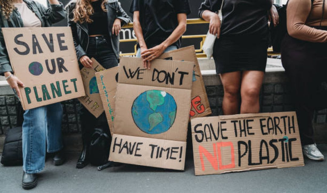 People are holding banner signs while they are going to a demonstration against climate change. Protest against global warming. Climate change protest concept.