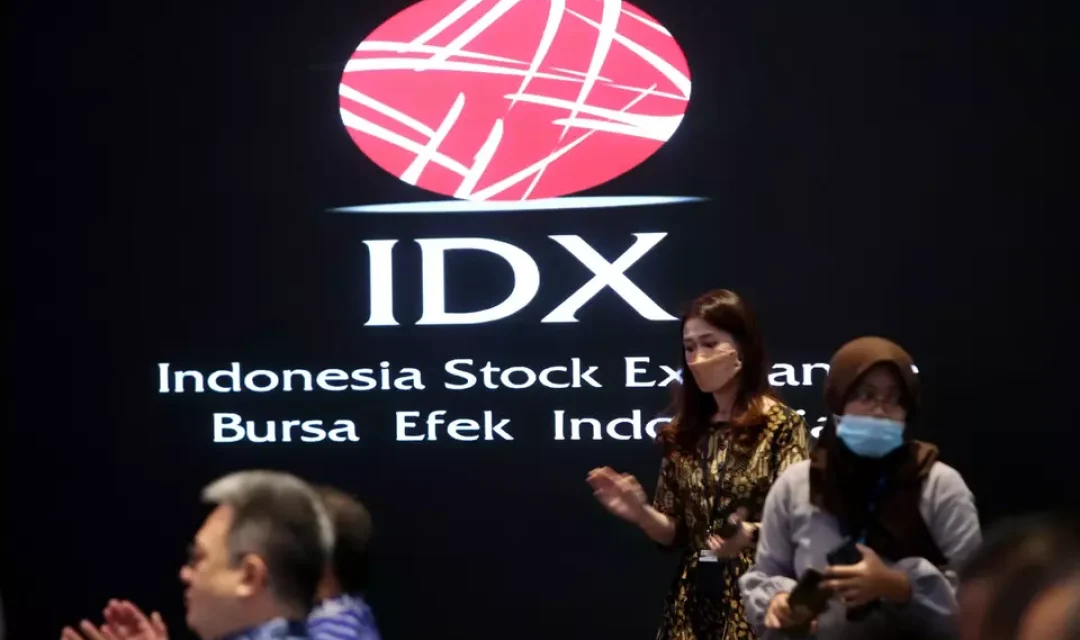 Karyawan berada dekat logo Bursa Efek Indonesia (BEI) di Jakarta.