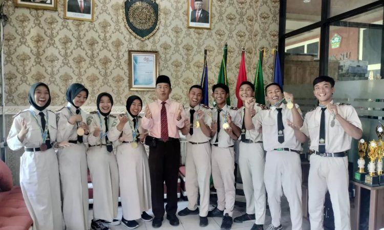 Kepala Sekolah Drs H. Abdul Mujib Syadzili MSi (tengah) bersama atlet Pagar Nusa berprestasi dari SMK NUSA. (jawapos.com)