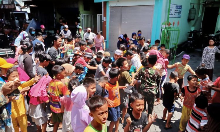 Anak-anak saat berebut uang koin dalam tradisi udik-udik di lingkungan Pesarean Raden Sawunggaling, Surabaya, Kamis (21/10/2021). Foto : (Istimewa)