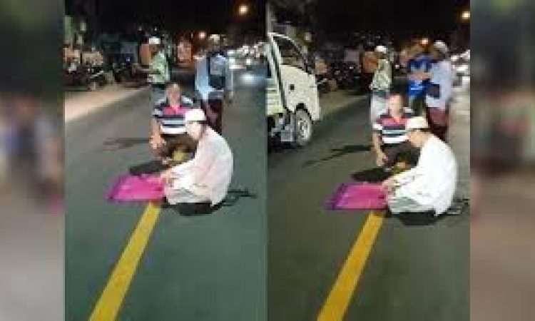 Seorag pria bikin heboh karena shalat di tengah jalan raya (Foto: Surya)