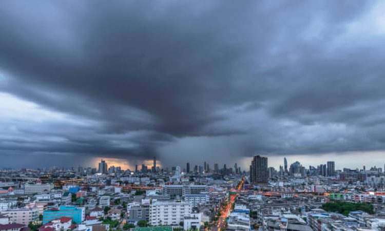 Modern city under dramatic stormy rainy clouds.