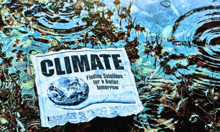 Cutting of simulated newspaper article about climate change outdoors in rainy weather in a swampy area. Text was written by the photographer, who also did the design and took the photo of the hand. Public domain satellite image from https://www.nasa.gov/multimedia/imagegallery/image_feature_2159.html