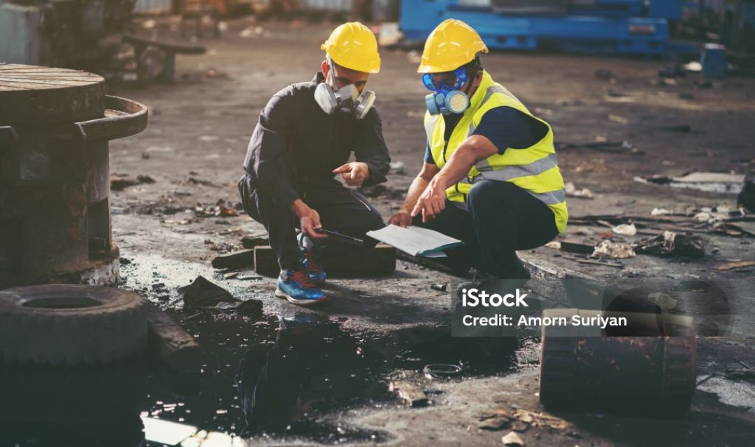 Chemical leak and safety first concept. Group of chemical specialist wear safety uniform, gas mask inspecting chemical leak in industry factory. Two scientists checking quality of liquid in plant