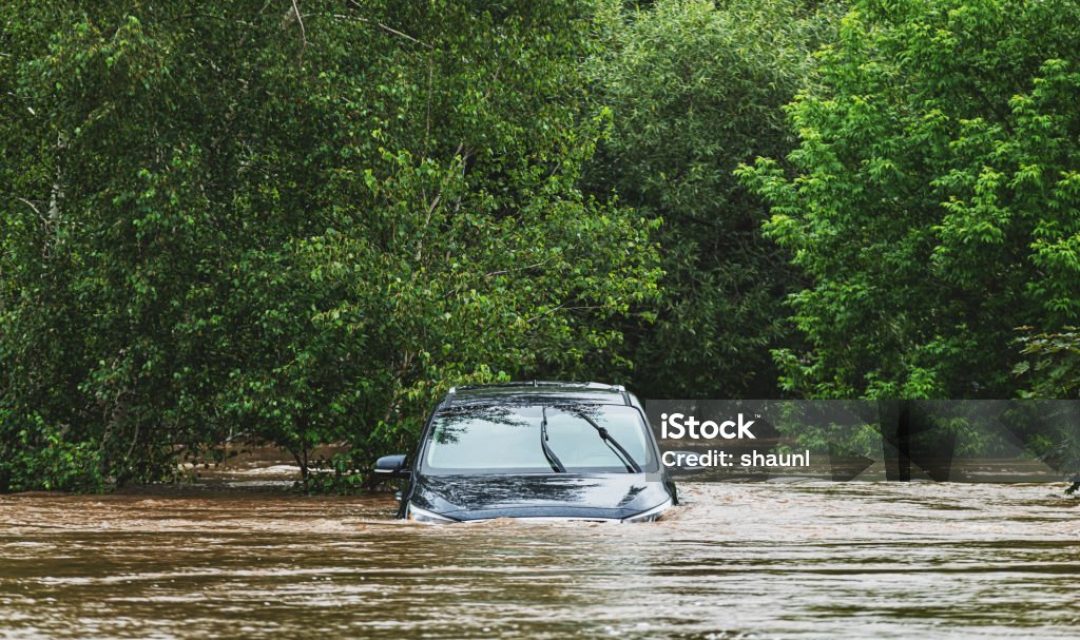 A vehicle sits in deep water after a river overflows following record breaking rainfall.