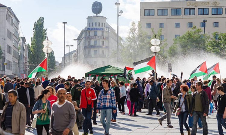 Munich, Germany - August 16, 2014: Pacific meeting against the rights infringement of the Palestinian population in Gaza, occupied of Israeli military forces. Activists with flags and slogans call for independence and freedom.